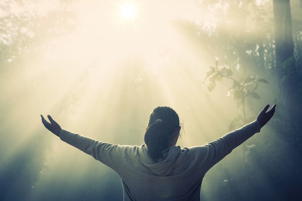 A woman with arms open amidst nature - Top 10 Signs You Are Spiritually Gifted